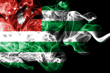 National flag of Abkhazia made from colored smoke isolated on black background. Abstract silky wave background.