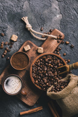 Fototapeta na wymiar Black fried coffee beans on dark textured background