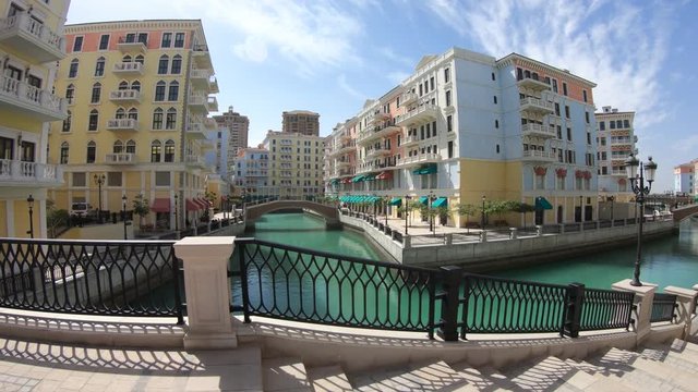 Little Venice with canals connected by bridges in venetian style. Colorful houses in picturesque Qanat Quartier icon of Doha, Qatar at daylight. Venice at the Pearl, Persian Gulf, Middle East.