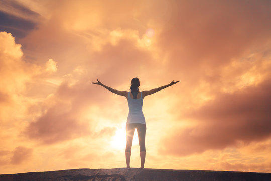 young woman with arms up to the sky feeling free and happy 