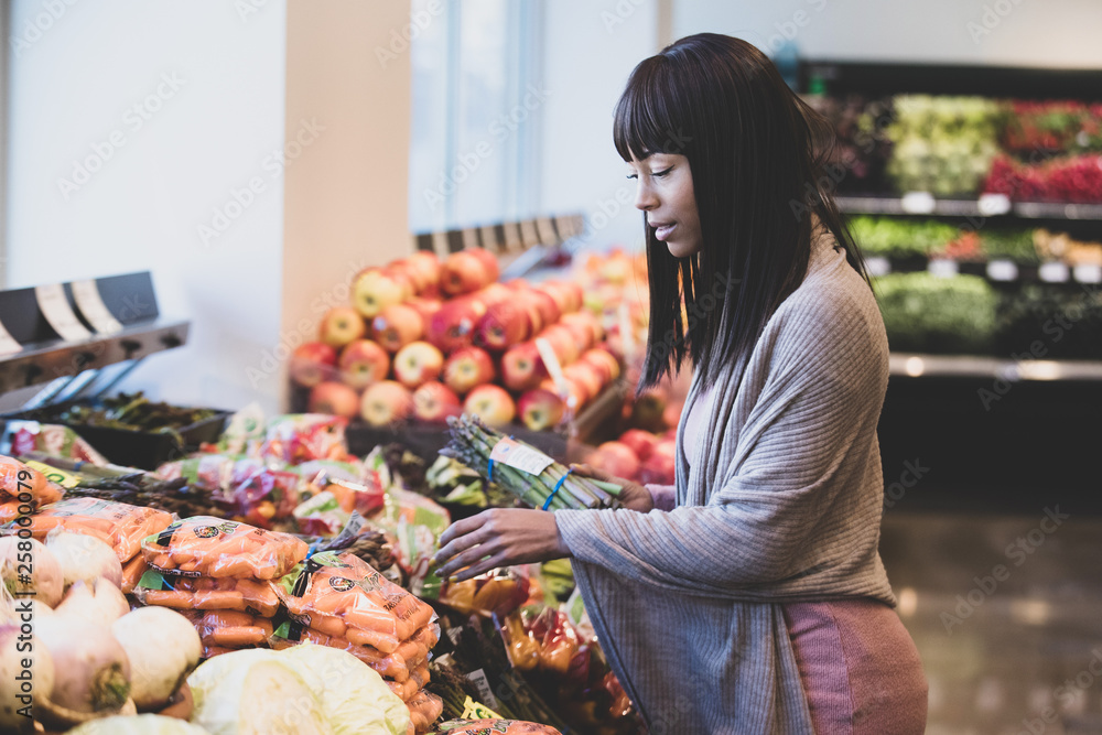 Wall mural african american woman shopping for produce in grocery store