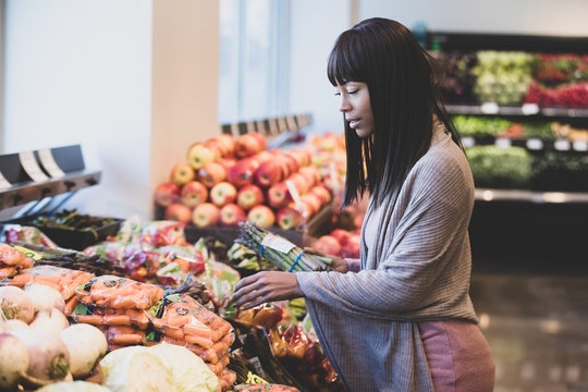 African American woman shopping for produce in grocery store