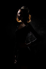 Portrait Silhouette Shadow Back Rim Light of Miss Pageant Beauty Queen Contest with Silver Diamond Crown wave hand express feeling smile, studio lighting dark black background © Jade