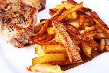 Grilled free-range beef steak with potato free, fresh tomatoes and sauce on a brown stone background