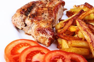 Grilled free-range beef steak with potato free, fresh tomatoes and sauce on a brown stone background