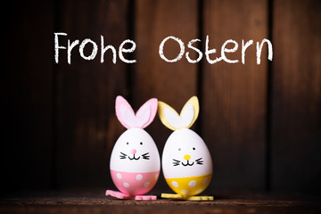 Ostereier mit Hasenohren vor Holzhintergrund