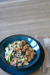 Fried chicken with sesame and zucchini and carrot salad with yoghurt sauce. Selective focus.
