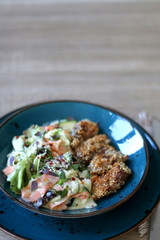 Fried chicken with sesame and zucchini and carrot salad with yoghurt sauce. Selective focus.