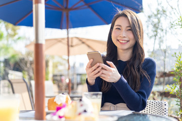 オープンテラスカフェで余暇を楽しみむ女性