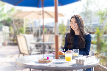 オープンテラスカフェで余暇を楽しみむ女性