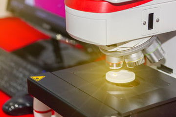 close up modern microscope for science laboratory or industrial work connect with computer on table