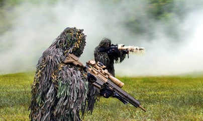 Military commando dressed in ghillie camouflage during  combat warfare