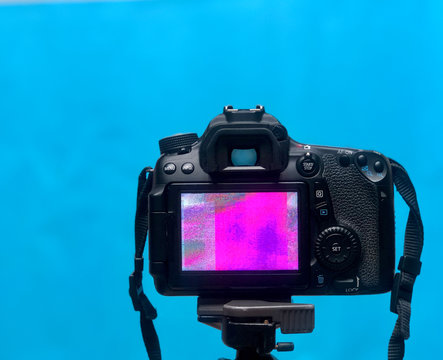DSLR LCD display screen with Pixel texture of the camera matrix on a tripod on blue Background - Powered by Adobe