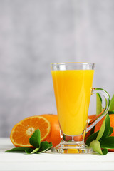 Glass of orange juice with oranges fruit on wooden table.
