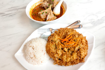 Rice with fried eggs and spicy pork ribs soup