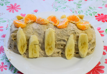 Cake with banana and tangerines, sprinkled with chocolate.