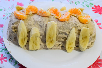 Cake with banana and tangerines, sprinkled with chocolate.