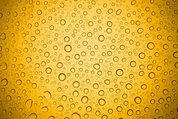 Water drops on yellow glass, Rain droplets on glass background.
