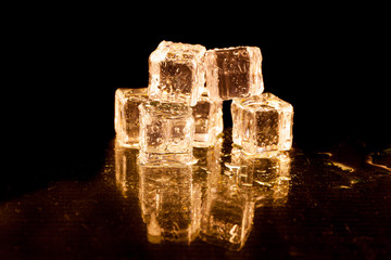 Gold ice cubes on black background.