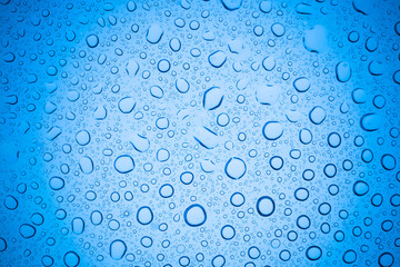 Rain droplets on blue glass background, Water drops on glass.