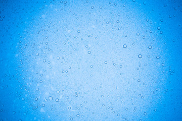 Rain droplets on blue glass background, Water drops on glass.