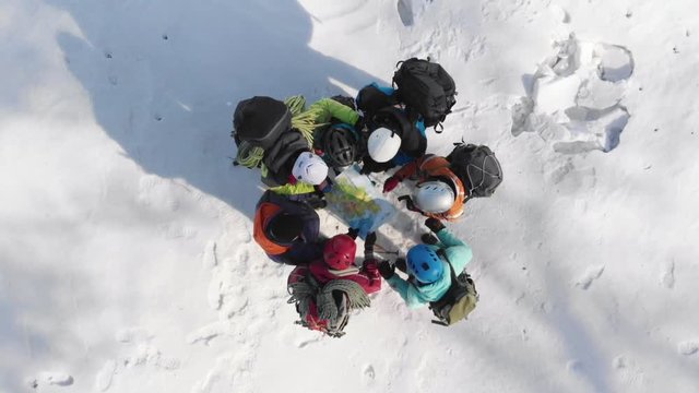 the climbers made camp on a hill and stood in a circle near the map, in order to choose the further direction of the route, in the campaign