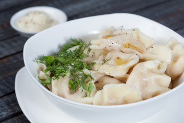 real, delicious, Russian dumplings on the table, with fresh herbs and spices, for cooking design.	