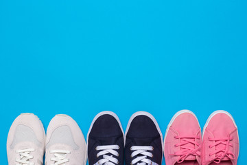 colorful  shoes top view. Set of different sneakers on blue background, copy space.