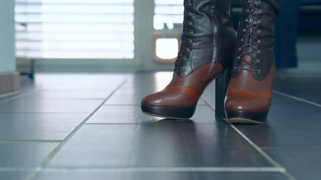 girl dance in her sexy high heels boots in front of the camera