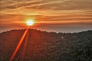Fototapeta na wymiar Dieses einzigartige Bild zeigt den schönen roten Sonnenuntergang mit großer Wolkenbildung hinter den Bergen in Hua Hin in Thailand
