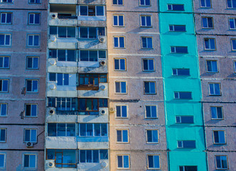 Fototapeta na wymiar Multi-storey building, nine floors, colored facade D pink, green, purple facade, windows, balconies. Panelka, panel house in Russia, in the province, in the provinces.
