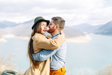 A beautiful couple travels in the mountains of Georgia. Lovestory in nature with a lake.