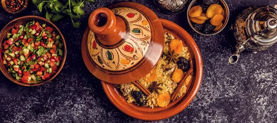 Zelfklevend Fotobehang Traditionele Marokkaanse tajine van kip met gedroogde vruchten en kruiden. © tbralnina