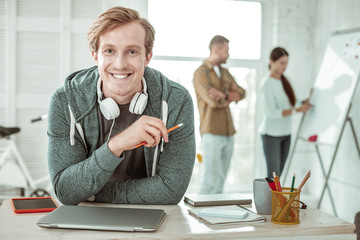 Happy handsome man holding a pencil in his hand