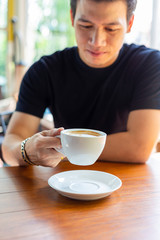 Young man holding a cup of hot coffee