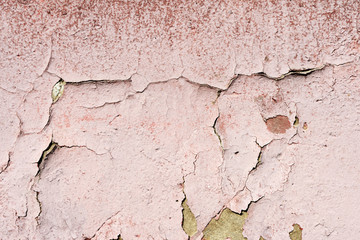 Old wall covered with cracked paint closeup as background and texture