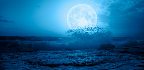 Night sky with moon in the clouds with dark sea 
