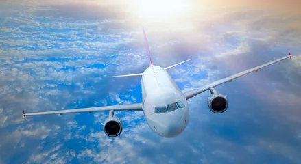Plexiglas keuken achterwand Vliegtuig White Passenger airplane in the clouds at sunset - Travel by air transport