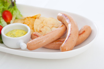Grilled sausages and grilled vegetables in craft trendy plate.