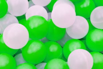 Close up of plastic white and green balls in dry pool on the playground