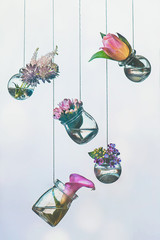 Flowers hanging in jars, pink and purple palette. Choosing items for an arrangement. DIY vase on a string with copy space.