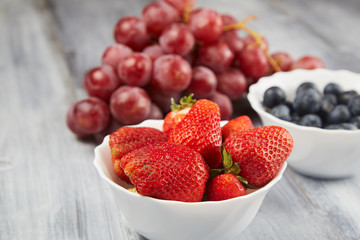 Berries and grapes on a gray wooden background