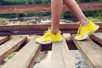 Yellow shoes sport style walking on wooden bridge