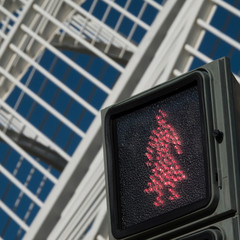 Pedestrian traffic light with woman in red waiting on the sreen..