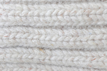 Light knitted texture closeup, visible yarn and fiber. The image is suitable as a background for various tasks.