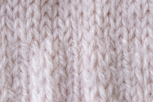 Light knitted texture closeup, visible yarn and fiber. The image is suitable as a background for various tasks.
