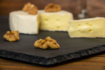 Camembert chopped in a dark background with nuts