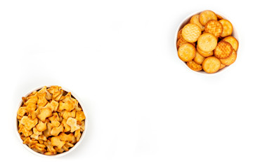 Salty crackers and fishes, shot from above on a white background with copy space. Party snacks banner with a place for text