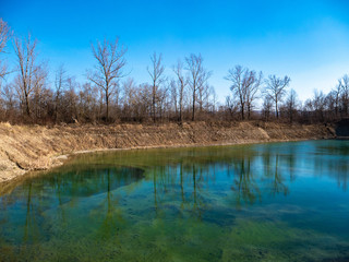 Mirror reflection of trees and clouds in the lake