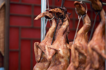 Roasted Peking ducks hanging in front of Chinese restaurant
